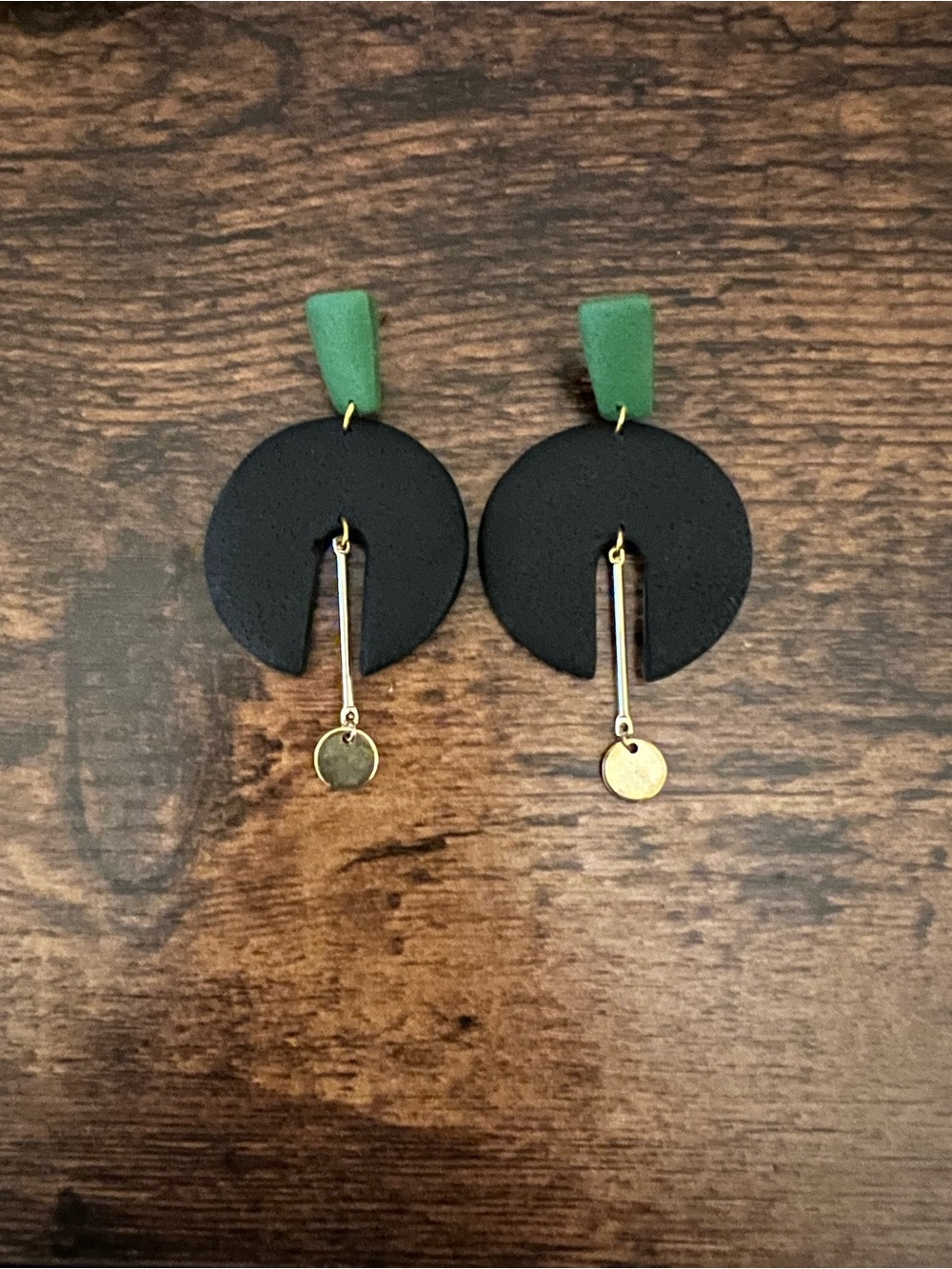 Black, green, and gold earrings
